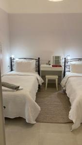 - une chambre avec 2 lits et une table avec un bureau dans l'établissement Chris AKROPOLI, à Athènes