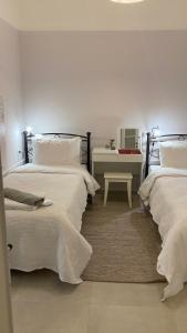 une chambre avec deux lits et une table avec un bureau dans l'établissement Chris AKROPOLI, à Athènes