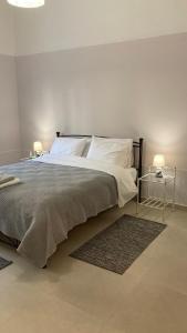 a bedroom with a large bed with two lamps at Chris AKROPOLI in Athens