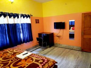 コルカタにあるHoliday Rental Roomsのベッドルーム(ベッド1台、デスク、テレビ付)