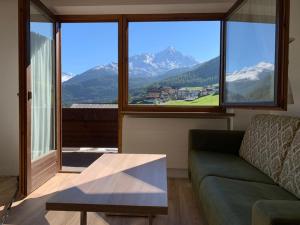 a living room with a couch and a large window at Haus Erwin Appartement in Sölden