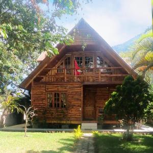 a wooden house with a red flag in front of it at Cabañas Típicas ARIAS in Oxapampa