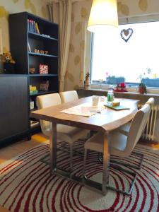 uma mesa de jantar com cadeiras brancas e um candeeiro em Ferienwohnung Harzluchs mit Balkon, Netflix und Sauna im Haus em Hohegeiß