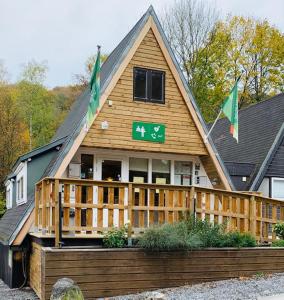 une maison arborant des drapeaux à l'avant dans l'établissement Chalet 126 - Durbuy, à Durbuy