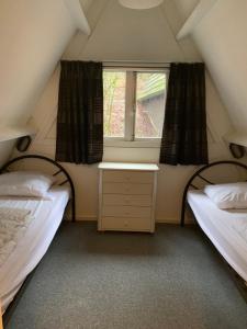 deux lits dans une petite pièce avec une fenêtre dans l'établissement Chalet 126 - Durbuy, à Durbuy