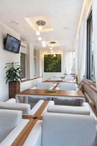 a conference room with white chairs and a large painting at Aurora Premier Hotel in Kharkiv