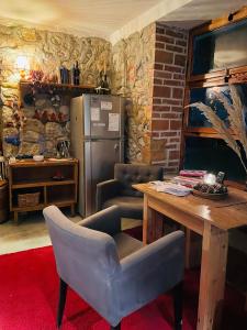 cocina con mesa y nevera en The house in the village en Tirana