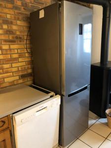 eine Küche mit einem Kühlschrank aus Edelstahl in der Unterkunft Gîte à la ferme chaleureux avec cheminée in Préveranges