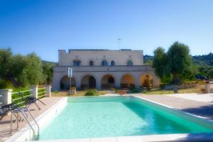 a large swimming pool in front of a building at La Piana degli Ulivi in Ostuni