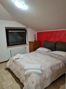 a bedroom with a large bed with a red headboard at landlady airport orio Bergamo Ida in Orio al Serio