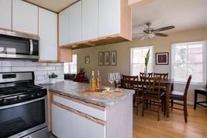 a kitchen with white cabinets and a dining room at Heartwell Park Beauty Long Beach in Long Beach