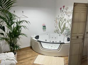Loft Ben A Ocaz في بن وقاص: حوض استحمام في غرفة بها نباتات