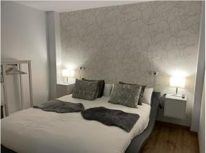 a bedroom with a large white bed with two lamps at Loft Ben A Ocaz in Benaocaz