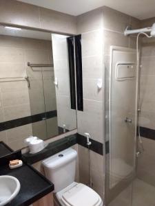 une salle de bain avec toilettes et douche en verre dans l'établissement Flat Praia do Cabo Branco - Casados para sempre!, à João Pessoa