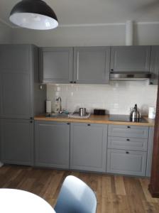 a kitchen with gray cabinets and a blue chair at Familijny in Toruń