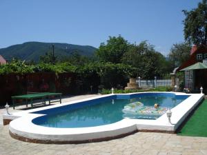 a swimming pool with a table and a bench in a yard at Casa Sia in Târgu Ocna