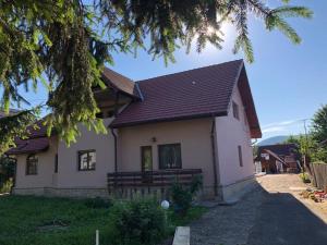 a white house with a brown roof at Casa Sia in Târgu Ocna