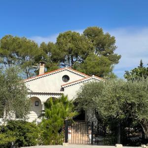 a white house with a chimney on top of it at Villa La Carpenée in Roquefort-les-Pins