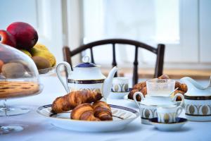 un tavolo con piatti di prodotti da forno e tazze di tè di Camera A Sud a Bovino
