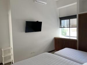 een slaapkamer met 2 bedden en een flatscreen-tv aan de muur bij Apartamento Mirador Del Laguito in Cartagena