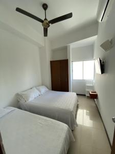 une chambre avec deux lits et un ventilateur de plafond dans l'établissement Hermoso y amplio apartamento en Cartagena de Indias, à Carthagène des Indes 18 autres photos