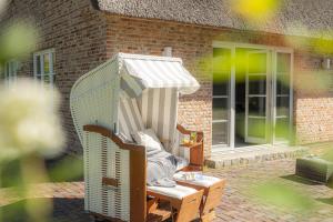 a wicker chair with an umbrella on a patio at Ferienhaus Koellers Hus in Böhl +3 photos