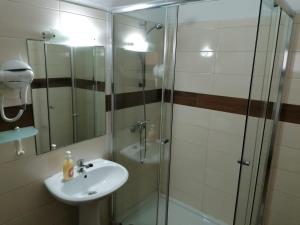 a bathroom with a sink and a glass shower at AAM jr in Albufeira