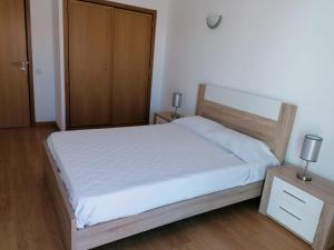 a bedroom with a bed and a wooden cabinet at AAM jr in Albufeira