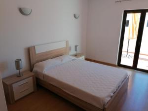a bedroom with a white bed and a window at AAM jr in Albufeira