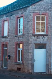 フィリップヴィルにあるLe Gîte de Zao avec billardの白いドアと3つの窓があるレンガ造りの建物