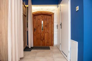 a hallway with a wooden door and blue walls at Stara Olejarnia in Nowe Miasto Lubawskie