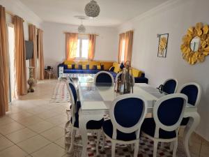 a dining room with a table and blue chairs at Kmi in Zarzis