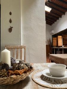una mesa con una vela y un tazón de uvas en Casa Rural La Coscoja, en Mérida