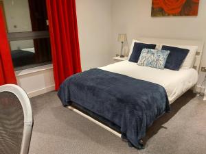 Schlafzimmer mit einem Bett und einem Fenster mit roten Vorhängen in der Unterkunft Large 2 Bed, 2 Bath, Free Parking & WiFi in Sheffield