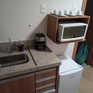 a kitchen with a sink and a microwave at Apartamento Hotel Vista Azul - Pedra Azul - ES in Domingos Martins