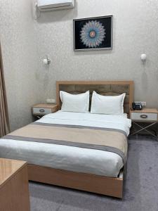 a bedroom with a large bed with two night stands at Reikartz Amirun Tashkent in Tashkent