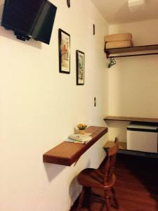 um quarto com uma secretária com uma cadeira e uma televisão em Morada das Pedras em Florianópolis