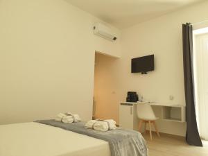 a bedroom with a bed and a desk and a tv at La Casa di Antonio Rooms in Palinuro