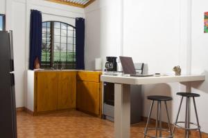 a kitchen with a table with a laptop on it at Basecamp Arenal in Tronadora