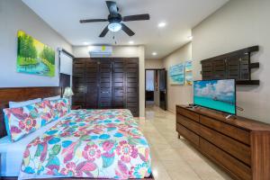 a bedroom with a bed and a flat screen tv at Penthouse Reef 401 - Beautiful Beachfront Ocean View - at El Faro in Playa del Carmen