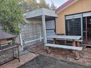 una mesa de picnic y un banco en un patio en Monoambiente Roger Balet, en Atlántida