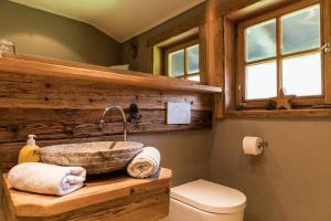 a bathroom with a stone sink on a wooden counter at Alpenchalet Reit im Winkl in Reit im Winkl