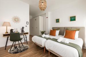 ポルトにあるPorto Essenceのデスクと椅子が備わる客室内のベッド2台