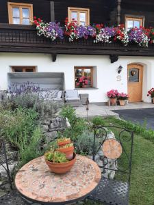 a garden with a table and flowers on a house at Appartement Huebgut in Bruck an der Großglocknerstraße