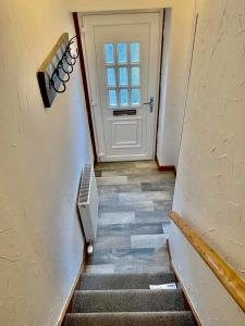 um corredor com uma porta e escadas com uma janela em Claire's Townhouse, Aberdeenshire, 3 bedrooms em Oldmeldrum