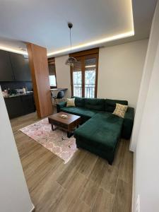 a living room with a green couch and a table at Duspara lux apartment Jahorina in Jahorina