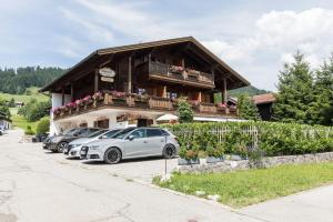 dos coches estacionados frente a un edificio en Alpenchalet Reit im Winkl, en Reit im Winkl