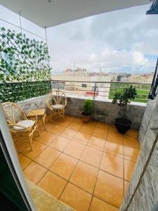 a balcony with chairs and a view of the city at welcom to castilla in Tangier