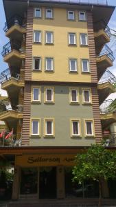 un edificio alto amarillo con muchas ventanas en Sailorson Apart Hotel, en Alanya