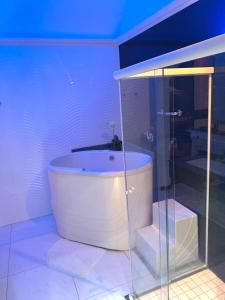 Flash Motel (Adult Only) في ساو فيسينتي: حوض استحمام أبيض في غرفة مع دش